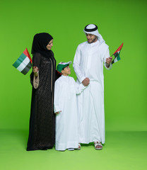 Arab family holding UAE national flag.