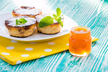 cheesecakes and jar of apricot jam on turquoise colored wooden table