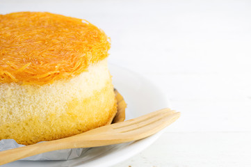 Gold egg yolks thread cake  on white wood background