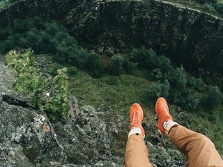 man's legs above hole in rock