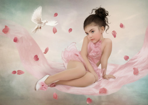 The little ballerina in pink tutu sitting on silk swing, surrounded by rose petals and white dove