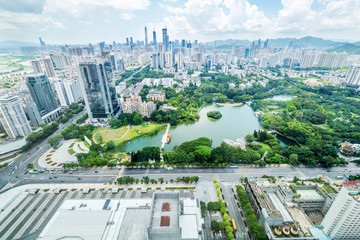 skyscrapers around a lake with greenland © zhu difeng