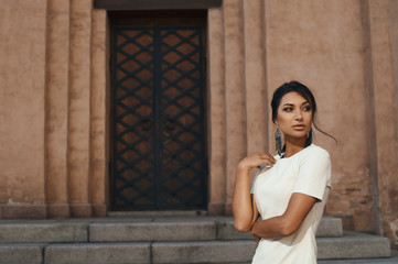 Fototapeta premium lady in dress against ancient building with thoughtful look