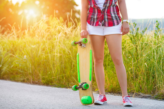 Anonymous hipster teenage girl with skateboard