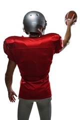 Rear view of sportsman in red jersey holding ball