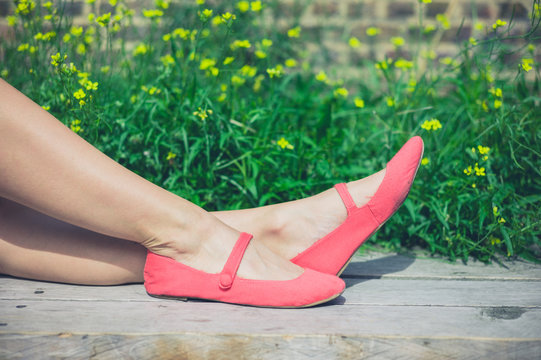 Feet of young woman relaxing on bench outside