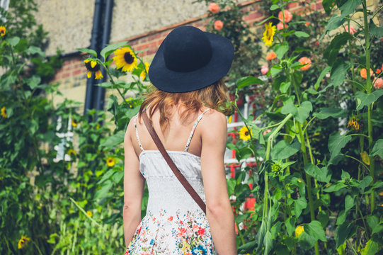 Woman with hat looking at sunflowers