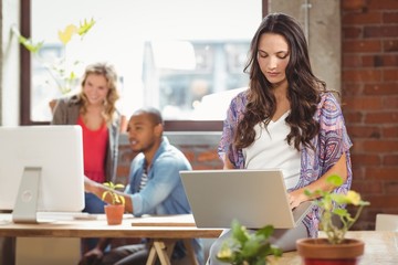 Businesswoman using laptop at creative office