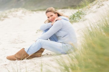 Smiling woman sitting on the sand