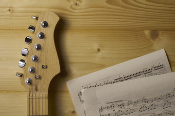 Guitar and Sheet music on wood.
