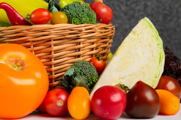 Still life of autumn vegetables in a basket on a gray background