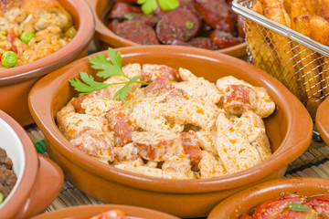 Tapas - Selection of latin dishes. Chorizo al vino, Higados de pollo, Chicken and chorizo, Tomates al ajillo, Arroz con pollo, Camarones enchilhados, Patatas a ala riojana and Stuffed mushrooms.
