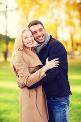 Fototapeta premium smiling couple hugging in autumn park
