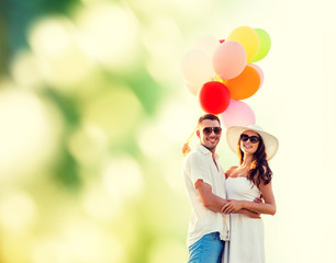 smiling couple with air balloons outdoors