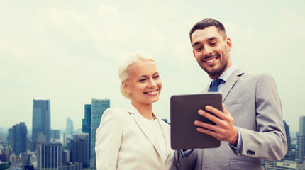 Fototapeta premium smiling businessmen with tablet pc in city