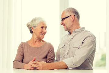 happy senior couple sitting on sofa at home
