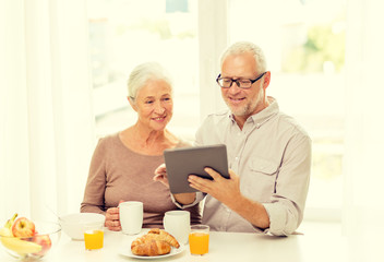 Fototapeta na wymiar happy senior couple with tablet pc at home