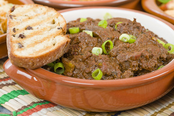 Higados de Pollo - Chicken livers with chorizo & spring onions finished with a dark Cajun tomato sauce served with crusty bread.