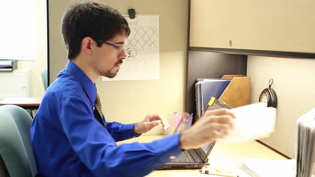 Man working on laptop in cubicle