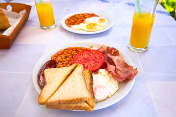 Full english breakfast with eggs, bacons, sausages and baked beans