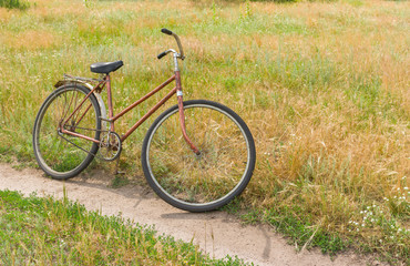 Fototapeta premium Ancient rusty bicycle waiting for the master on the roadside