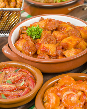 Patatas a la Riojana - Potato, chorizo and peppers stew. Surrounded by other tapas dishes.