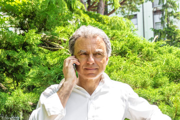 Handsome middle-aged man talking on mobile phone