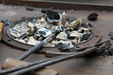 Кузнечный щипцы и уголь