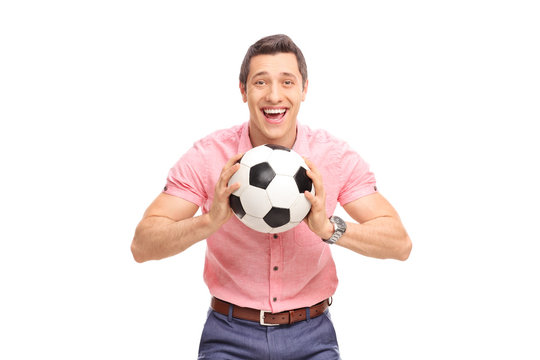 Joyful young guy holding a football