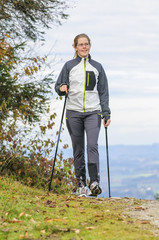 junge Frau hält sich fit mit Nordic Walking