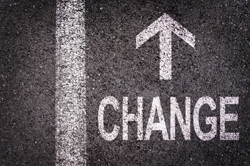 Word change and an arrow written on an asphalt road background