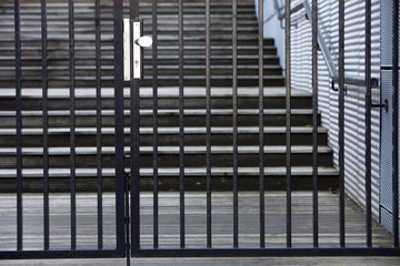 Closed security gate with a staircase in the background