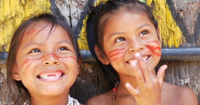 Cute native Brazilians smiling at an indigenous tribe in the Amazon