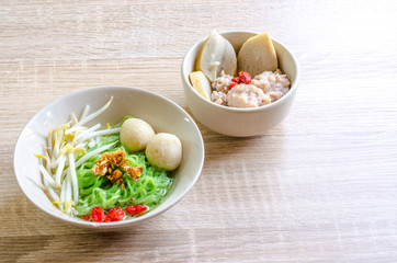 Thai Noodle with meat ball and crispy pork skin on wooden backgr