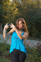 Girl listening music with headphones and holding a smart phone