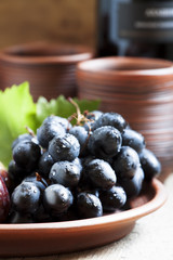 Ripe figs and grapes on a clay plate in a rustic style, selectiv