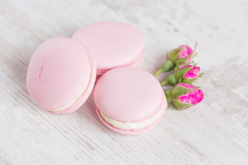 Tender pink macaroons on white wood background