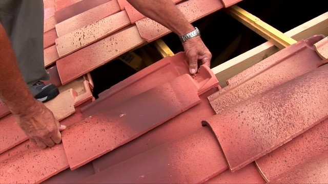 Le couvreur refait  le toit d'une maison