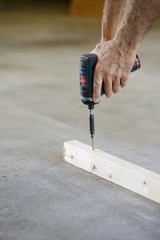 Closeup of Hands of Worker Using Drill