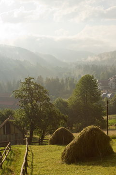 rural landscape with haystacks on a hillside amidst the mountain