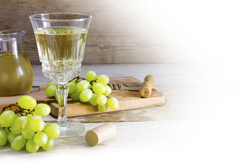 wine and green grapes on rustic wood, corner background on white