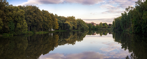 Autumn river panorama with reflections on water surface in Troitsk city park