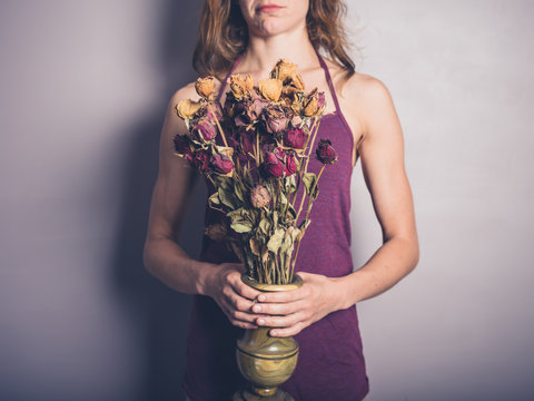 Young woman with dead flowers