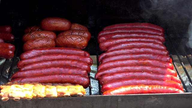 Cooking of sausages on the charcoal barbecue grill.