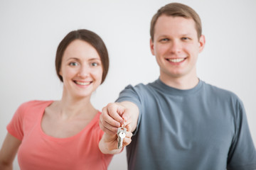 Happy young man and woman holding a bunch of keys