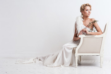 Beauty woman with wedding hairstyle and makeup. Bride fashion. Jewelry and Beauty. Woman in white dress,perfect skin, blond hair. Girl with stylish haircut. .Wedding decoration. Bride with flowers