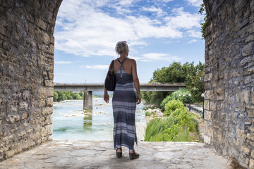 Woman standing on the bridge looking at the View of Arachthos ri