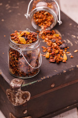 Granola, honey, raisins, peanuts and sunflower seeds, vintage suitcases.selective focus