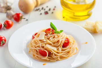 Italian spaghetti with tomato sauce, parmsesan cheese and basil on table