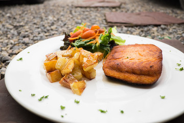salmon steak with roast potato and salad